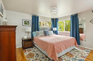 貝爾維尤的住宿－Big Home blocks to Dwtn Bellevue!，一间卧室配有一张带蓝色窗帘的床和一扇窗户