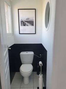 uma casa de banho com WC e uma fotografia na parede em L'Abri Côtier, l'appart 60m2, 1 chb avec terrasse em Caux