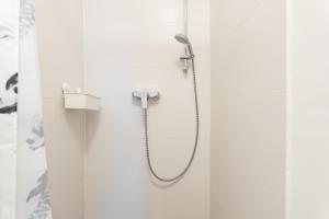 a shower in a bathroom with white walls at Apartment Hotel Triester in Vienna