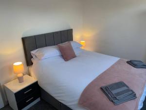 a bedroom with a large white bed with two pillows at The Willows in Brighouse