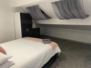 sypialnia z dużym łóżkiem z szarymi zasłonami w obiekcie The Willows w mieście Brighouse
