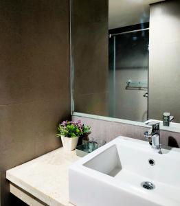 y baño con lavabo blanco y espejo. en Apartemen Amarta, one bedroom - by Beatrice, en Beran-kidul