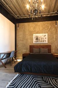 een slaapkamer met een bed en een kroonluchter bij Elegante LOFT 6 con vista a la ciudad in Mexico-Stad