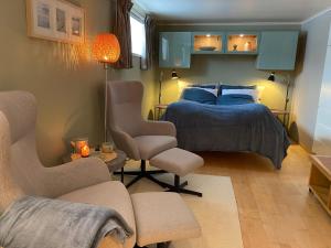 1 dormitorio con 1 cama, 2 sillas y mesa en Leilighet sentralt til Sandefjord og Torp flyplass, en Sandefjord
