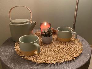 a table topped with two cups and a candle at Leilighet sentralt til Sandefjord og Torp flyplass in Sandefjord