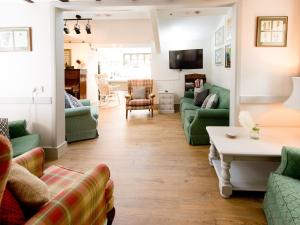 uma sala de estar com sofás verdes e uma mesa em Crown Inn em Woolhope
