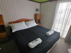 1 dormitorio con 1 cama con 2 toallas en Catema, en Coyhaique