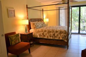 a bedroom with a canopy bed and a chair at Tranquility by the Beach in Key West +41 photos