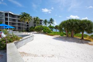 a beach with palm trees and a building at Tranquility by the Beach in Key West