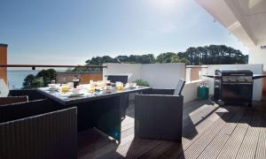 a patio with a table and chairs on a balcony at Curlew 3 - The Cove in Brixham
