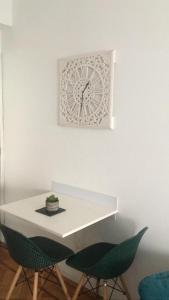 Studio Calm In Fabrica في بورتو: طاولة بيضاء مع كرسيين وساعة على الحائط