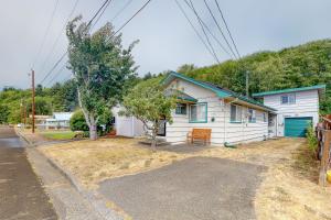 a small white house with a green garage at Bay Bliss in Reedsport