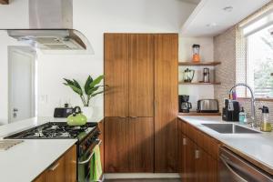 a kitchen with wooden cabinets and a stove top oven at Quiet Haven with Huge Fenced Yard Fast Internet by Lodgewell in Austin