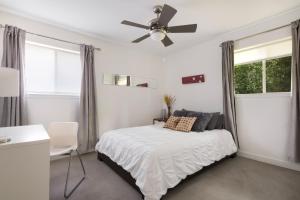 a white bedroom with a bed and a ceiling fan at Quiet Haven with Huge Fenced Yard Fast Internet by Lodgewell in Austin