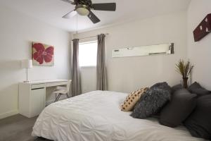 a bedroom with a bed with a ceiling fan and a desk at Quiet Haven with Huge Fenced Yard Fast Internet by Lodgewell in Austin