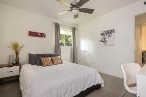 a white bedroom with a bed and a ceiling fan at Quiet Haven with Huge Fenced Yard Fast Internet by Lodgewell in Austin