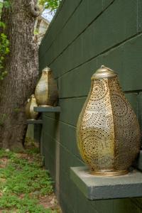 three vases sitting on a wall next to a tree at Quiet Haven with Huge Fenced Yard Fast Internet by Lodgewell in Austin