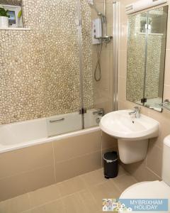 a bathroom with a tub and a sink and a shower at Curlew 5 - The Cove in Brixham