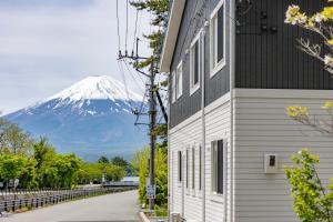 un edificio con una montaña cubierta de nieve en el fondo en はまゆり, en Azagawa