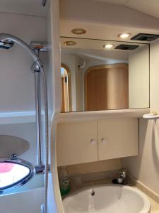 a bathroom with a sink and a shower with a mirror at Luxury Yacht Kamikara in San Miguel de Abona