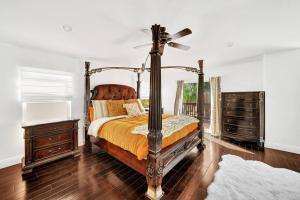 a bedroom with a canopy bed and a fan at Vino Villa Large home Sleeps 10! Large Salt water pool/spa in Murrieta +33 photos