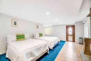 two beds in a room with white walls and blue carpet at Live Laugh Lake - A in Rushville