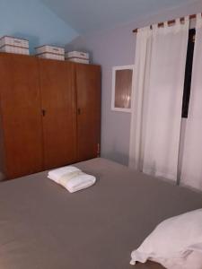 1 dormitorio con 1 cama con 2 toallas en •JADE• Casas de alquiler en Los Molles
