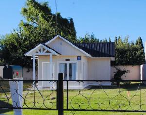 una pequeña casa blanca con techo negro en Calafate Drome en El Calafate