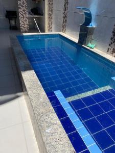 a blue tile swimming pool with a fountain at Sol e Praia in Prado