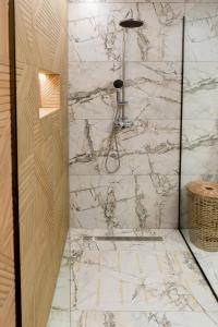 a bathroom with a shower with a marble wall at Antonakis Villa, Near Beach, Private Pool in Kremasti