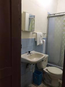 a bathroom with a sink and a toilet at Hotel Luque in Guayaquil