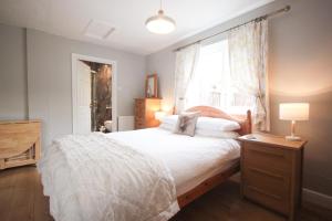 een slaapkamer met een groot bed en een raam bij The Five Dials Inn in Ilminster