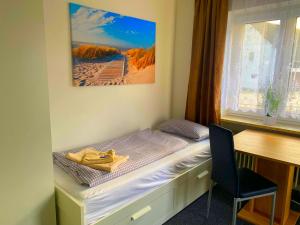 a room with a bed and a desk and a window at Ferienhaus Heimberg - Fischach in Fischach