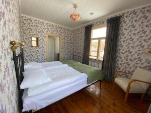 ein Schlafzimmer mit einem Bett in einem Zimmer mit Tapete in der Unterkunft Strandgården Hoverberg. in Svenstavik