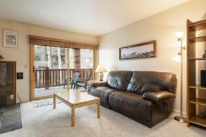 a living room with a leather couch and a table at SNOW FLOWER 066-Studio condo in Park City