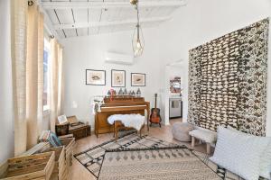 ein Wohnzimmer mit einem Klavier und einem Stuhl in der Unterkunft The Desert Nomad Retreat in Joshua Tree Village in Joshua Tree