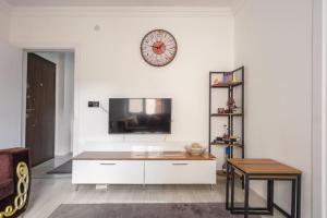 a living room with a tv and a clock on the wall at Center of Cappadocia, High Speed ​​Internet in Urgup