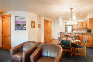 ein Esszimmer mit einem Tisch und Ledersesseln in der Unterkunft SNOW FLOWER 149 condo in Park City
