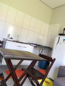 Una pequeña cocina con una mesa y un refrigerador. en CASA DE TEMPORADA DA MEiRE, en Carolina