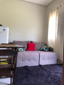 Una sala de estar con un sofá con almohadas. en CASA DE TEMPORADA DA MEiRE, en Carolina