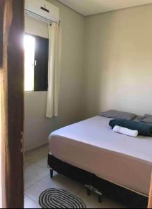 Un dormitorio con una cama en una habitación con ventana. en CASA DE TEMPORADA DA MEiRE, en Carolina