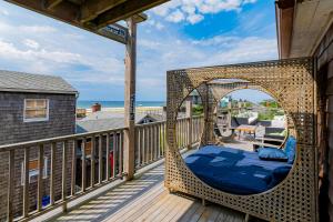 a bed in a wicker swing on a balcony with the ocean at 34 Champlain Unit 1 and Penthouse in Ocean Bay Park