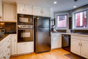 a kitchen with white cabinets and a stainless steel refrigerator at MOTHERLODE 3 townhouse in Park City