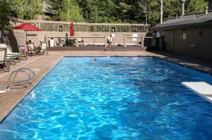 a large blue swimming pool with a person in it at LAKESIDE 1629 townhouse in Park City