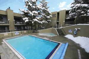 a swimming pool with snow in front of a building at EDELWEISS HAUS 115A condo in Park City