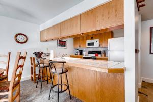 a kitchen with wooden cabinets and a counter with bar stools at FASHION COALITION 402 condo in Park City