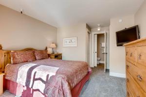 a bedroom with a bed and a flat screen tv at FASHION COALITION 402 condo in Park City