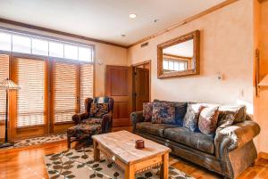 a living room with a leather couch and a table at LIFT LODGE 203 condo in Park City