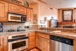 a kitchen with wooden cabinets and stainless steel appliances at LIFT LODGE 203 condo in Park City +31 photos