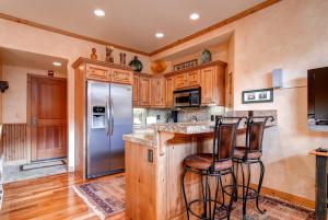 a kitchen with a refrigerator and two bar stools at LIFT LODGE 203 condo in Park City